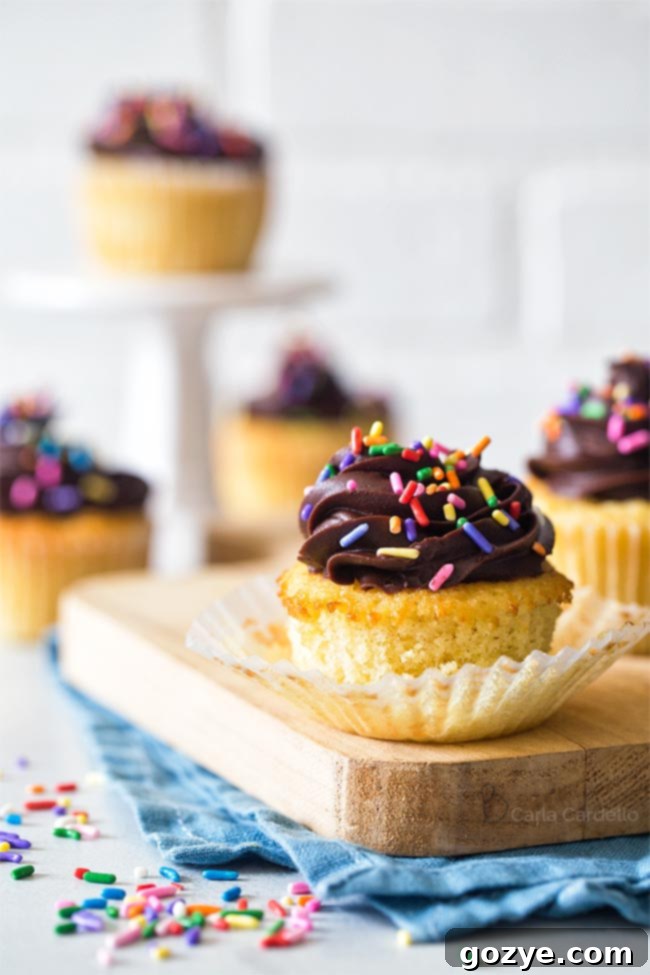 Small Batch Yellow Cupcakes with peeled liner revealing fluffy cake