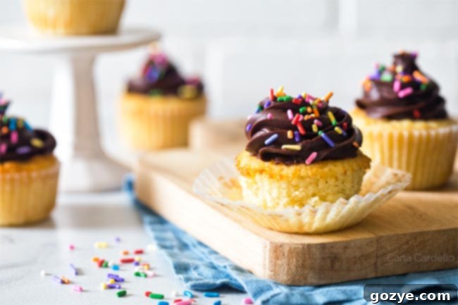 Small Batch Yellow Cupcakes with paper liner peeled back showing the crumb