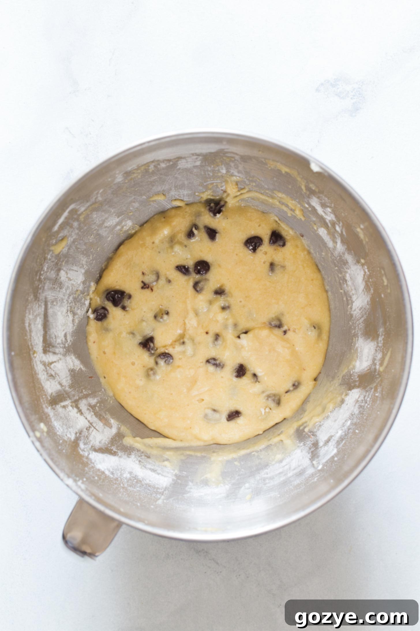 Adding chocolate chips to banana muffin batter, stirred gently