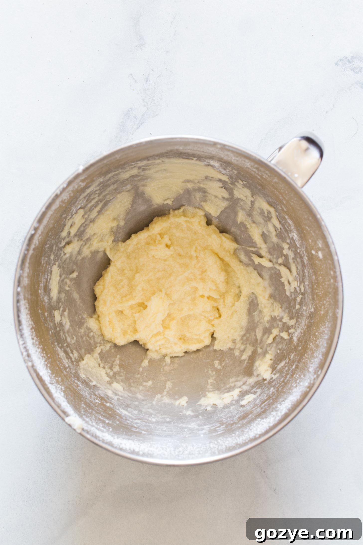 Adding cooled coconut milk mixture and coconut extract to creamed butter and sugar