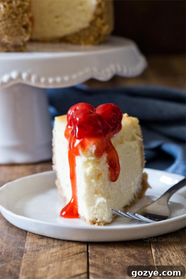 A slice of 6 inch cheesecake recipe on a plate, showing the creamy texture and a bite taken out.