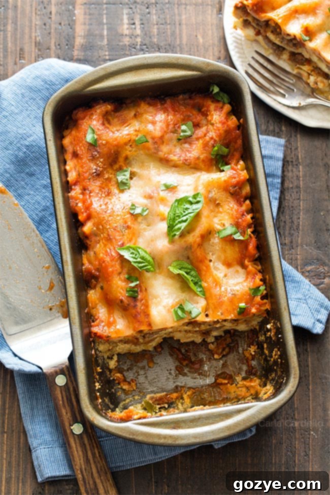 Perfectly baked Lasagna For Two in a loaf pan, showing the golden cheese crust and layered filling