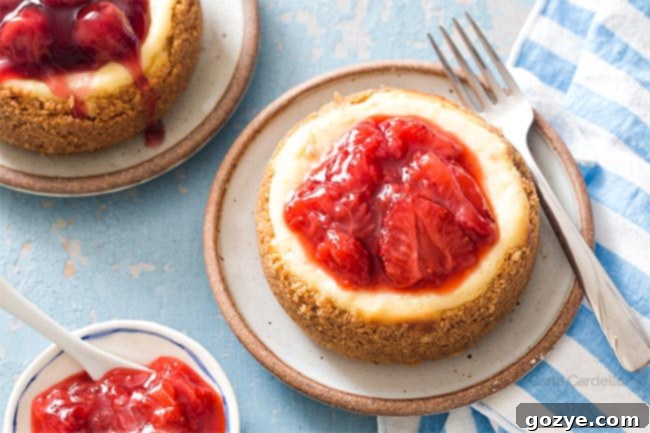 A 4-inch cheesecake topped with vibrant strawberry sauce and cherry pie filling, showcasing its perfect size.