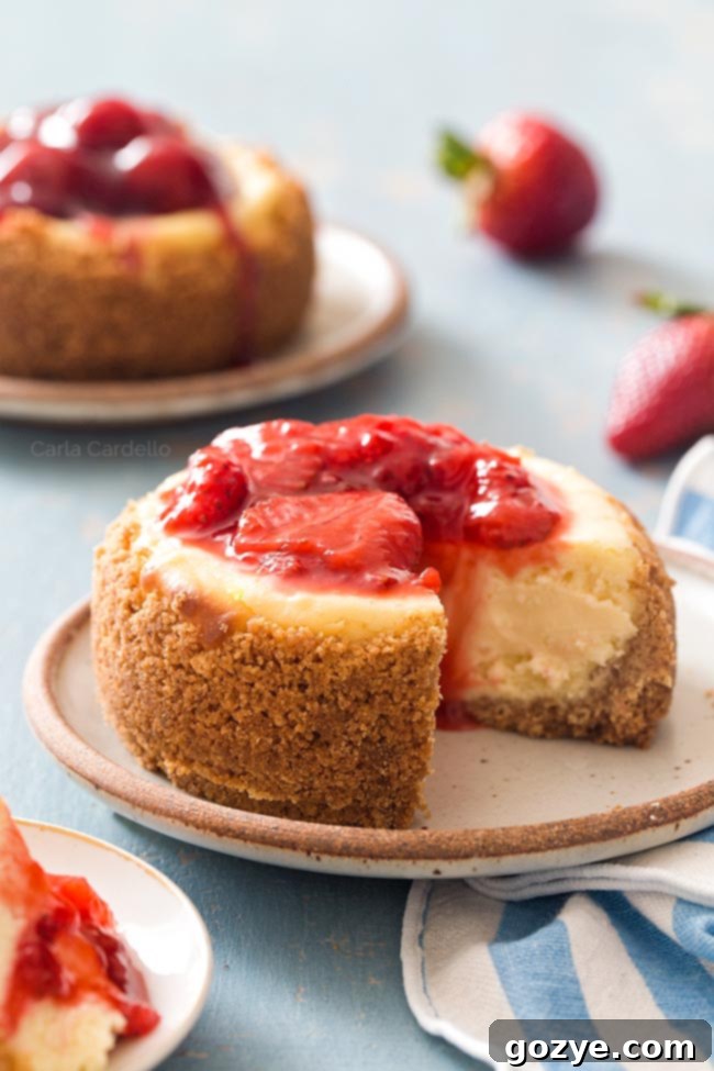 A beautifully garnished 4-inch cheesecake with fresh strawberry sauce, ready for serving.