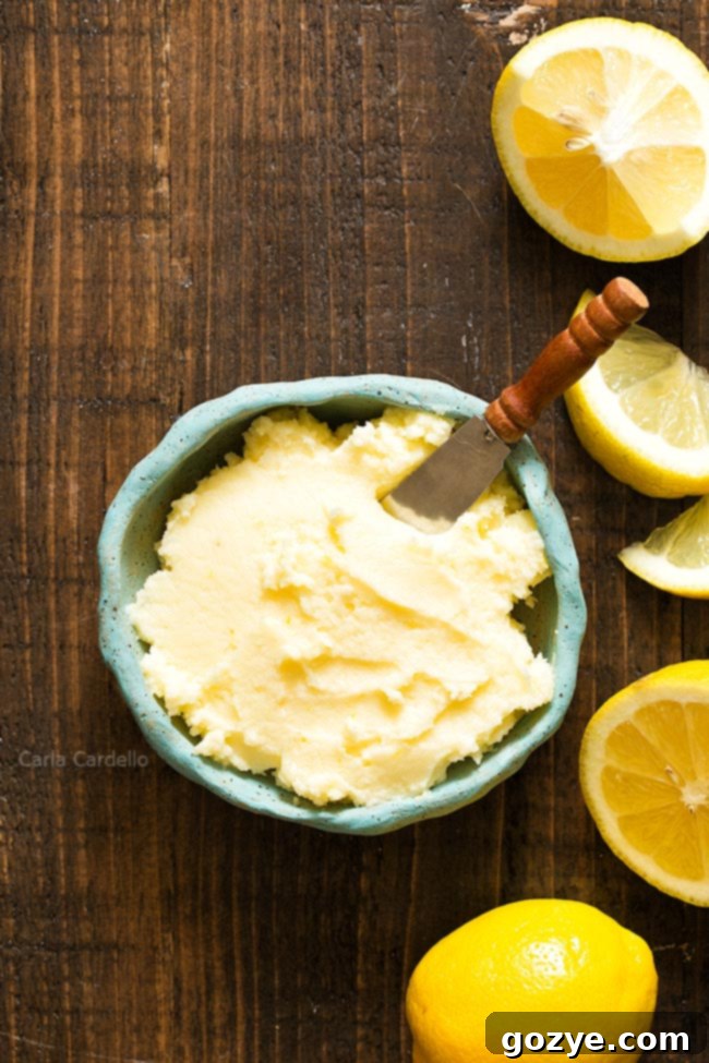 Blue bowl of homemade Lemon Buttercream Frosting with fresh lemon slices, ready to be used