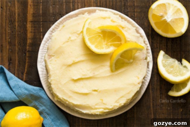 Close-up of a frosted cake with lemon buttercream and lemon slices, ready to be served