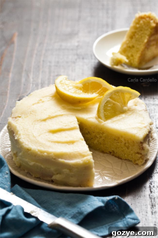 6 inch lemon cake with a slice removed, revealing yellow crumb