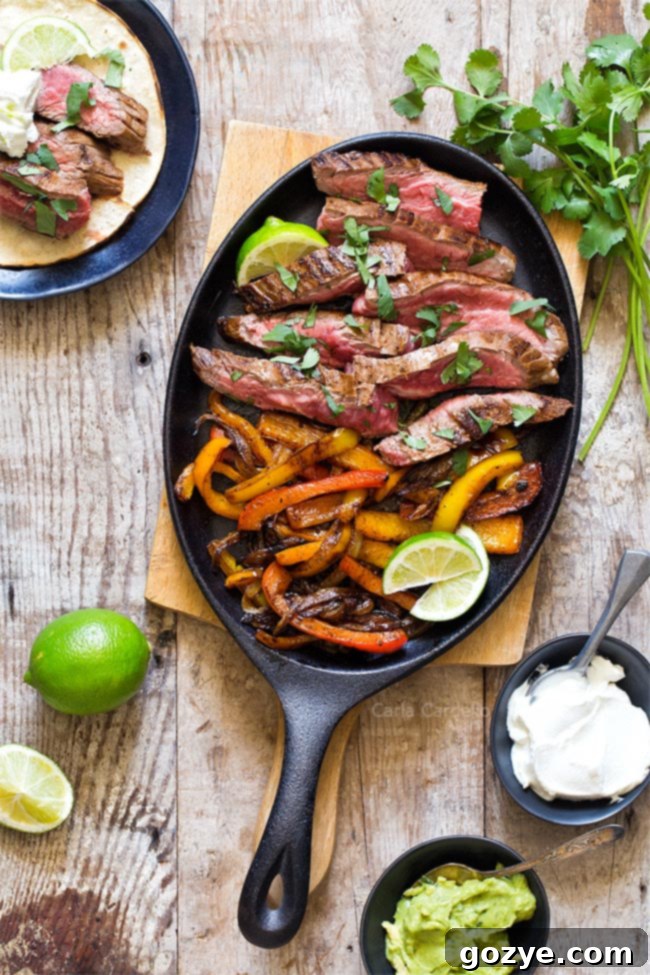 Sizzling steak fajita meat and vibrant bell peppers cooking in a cast iron pan