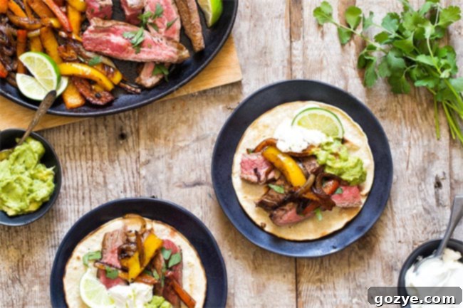 Two servings of delicious Steak Fajitas presented on corn tortillas with a side of guacamole