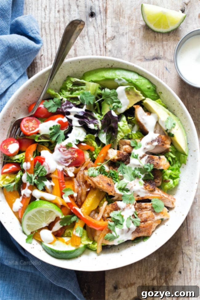 Chicken Fajita Salad with ranch dressing drizzled generously over it, ready to be served