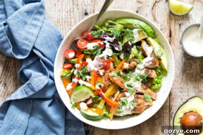 Fajita salad in bowl, featuring grilled chicken, peppers, avocado, and tomatoes