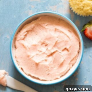 Strawberry frosting in bowl, ready to be spread or piped onto baked goods.
