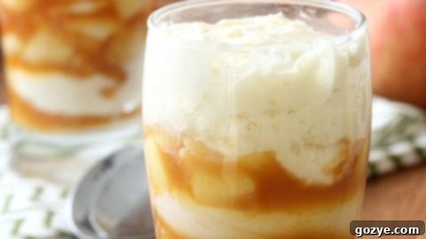 Layers of creamy cheesecake and caramel apple filling in a parfait glass