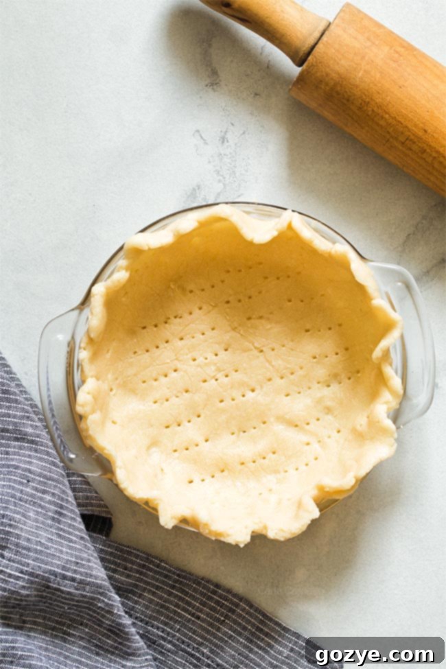 Unbaked pie dough beautifully crimped in a 6-inch pie plate, ready for filling