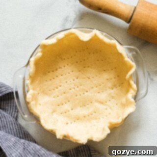 Beautifully crimped unbaked pie dough in a 6-inch pie plate, ready for baking