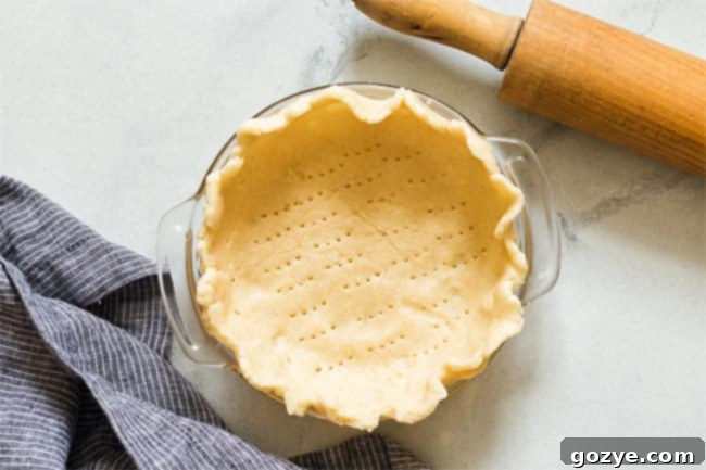 Another view of unbaked pie dough in a 6-inch pie plate, showcasing its texture