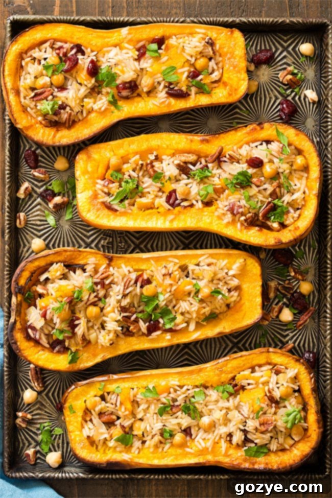 Savory Stuffed Butternut Squash 7 Four beautifully stuffed butternut squash halves on a baking sheet, golden and ready to serve.