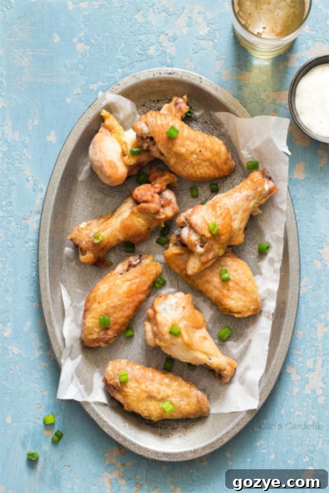 crispy wings on a silver plate with blue background