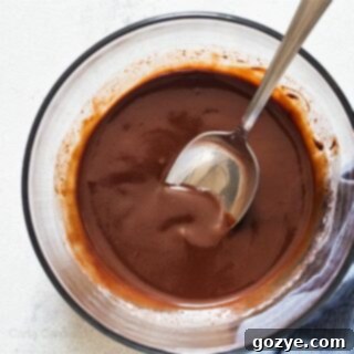 Glass bowl filled with chocolate ganache, a perfect glaze for desserts.