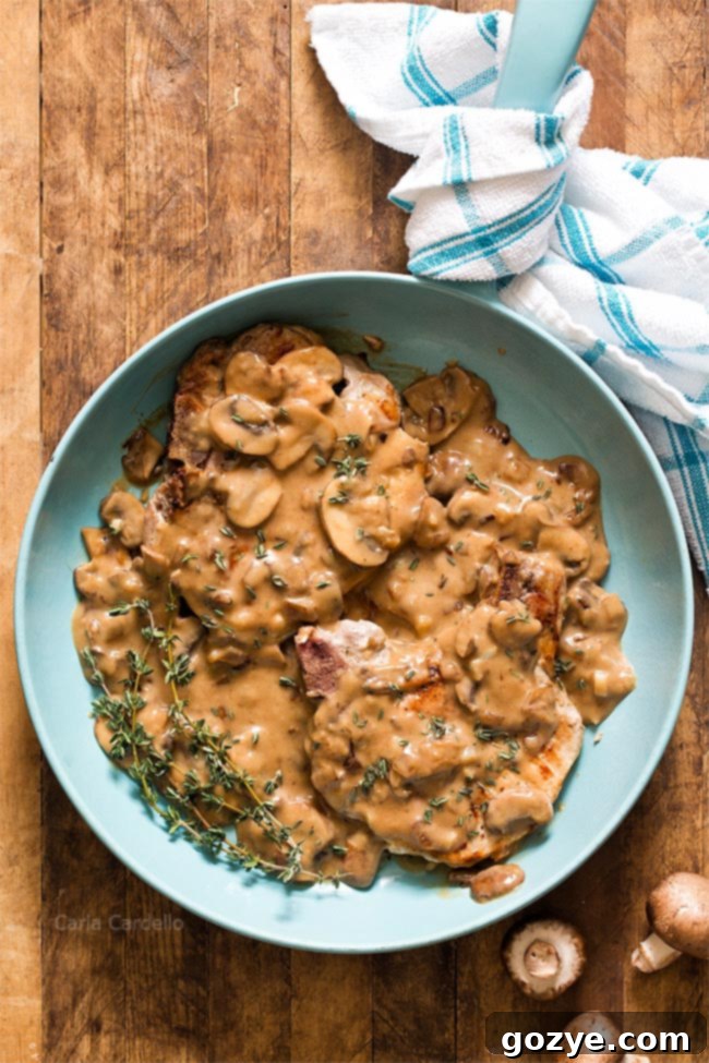 Pork chops with mushroom gravy in blue skillet