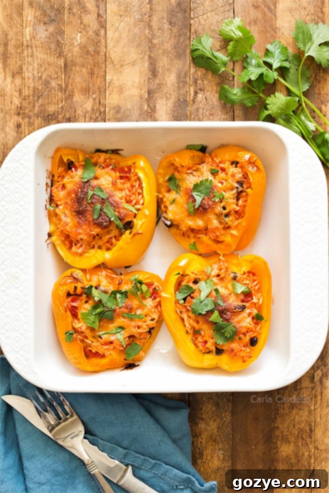 4 stuffed pepper halves in white baking dish