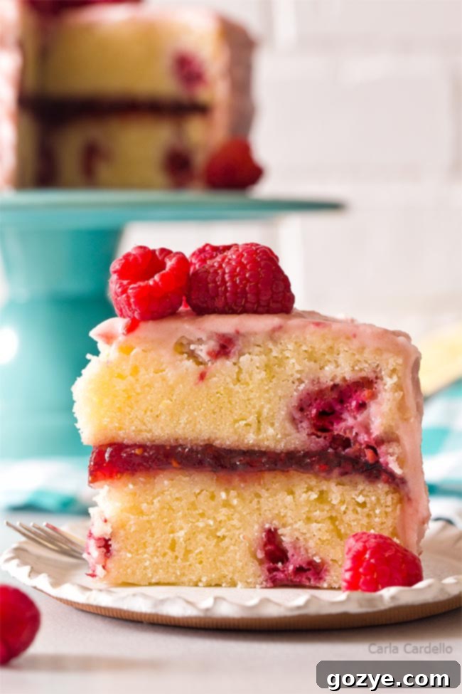 A top-down view of a slice of lemon raspberry cake, highlighting the layers and fresh raspberries