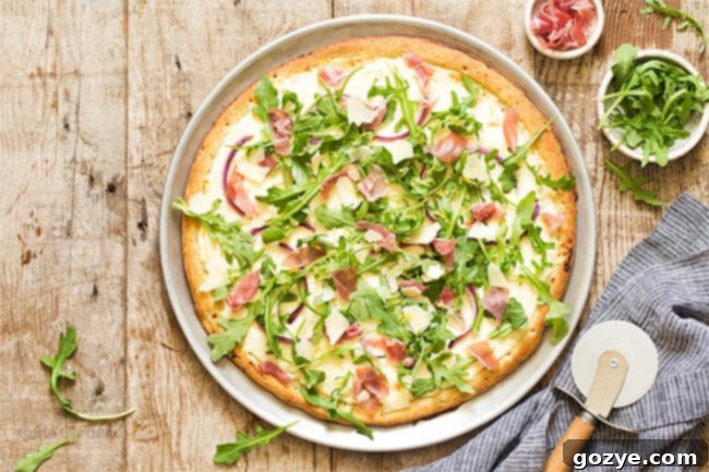 Prosciutto and Arugula Pizza 7 Prosciutto Arugula Pizza on a pizza pan with pizza cutter