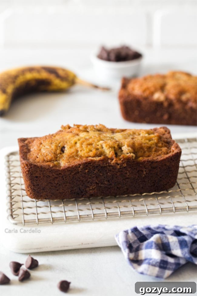 Petite Banana Bread Delights 2 Two golden brown mini banana bread loaves resting on a rustic cutting board