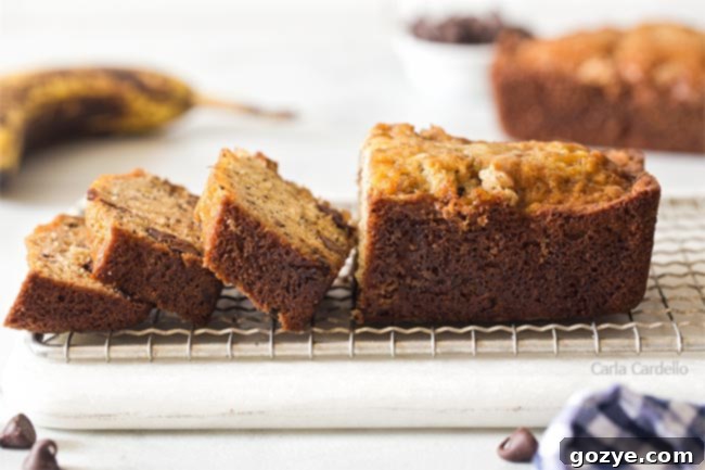 Petite Banana Bread Delights 10 A sliced mini banana bread loaf on a cutting board, showing its moist crumb and chocolate chips