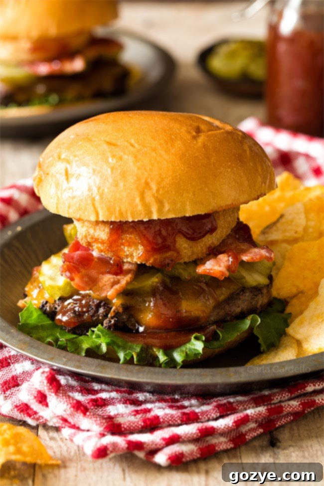 Delicious BBQ Bacon Burgers served on a plate with potato chips, ready to eat