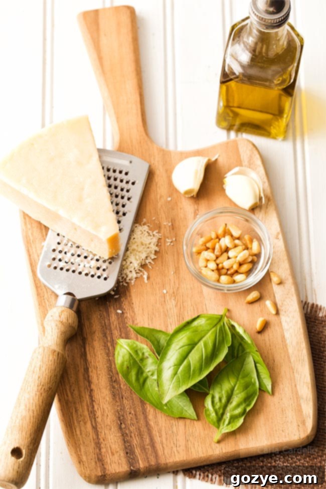 Fresh ingredients for basil pesto laid out on a wooden cutting board