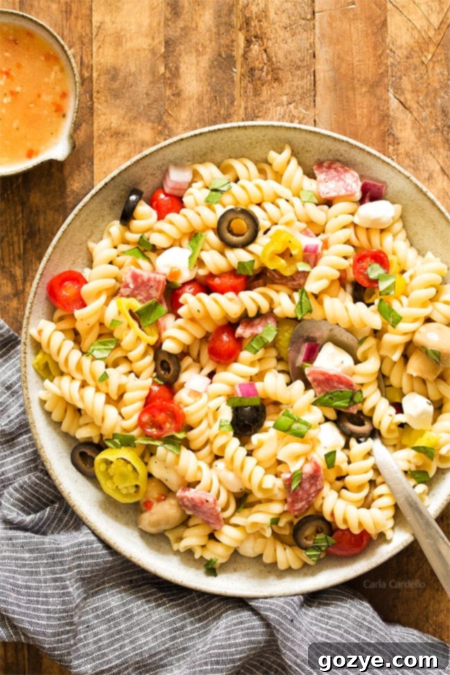 Large bowl of Antipasto Pasta Salad with Italian dressing, ready to be served on a table
