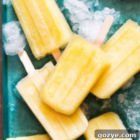Pile of pineapple popsicles on a teal tray
