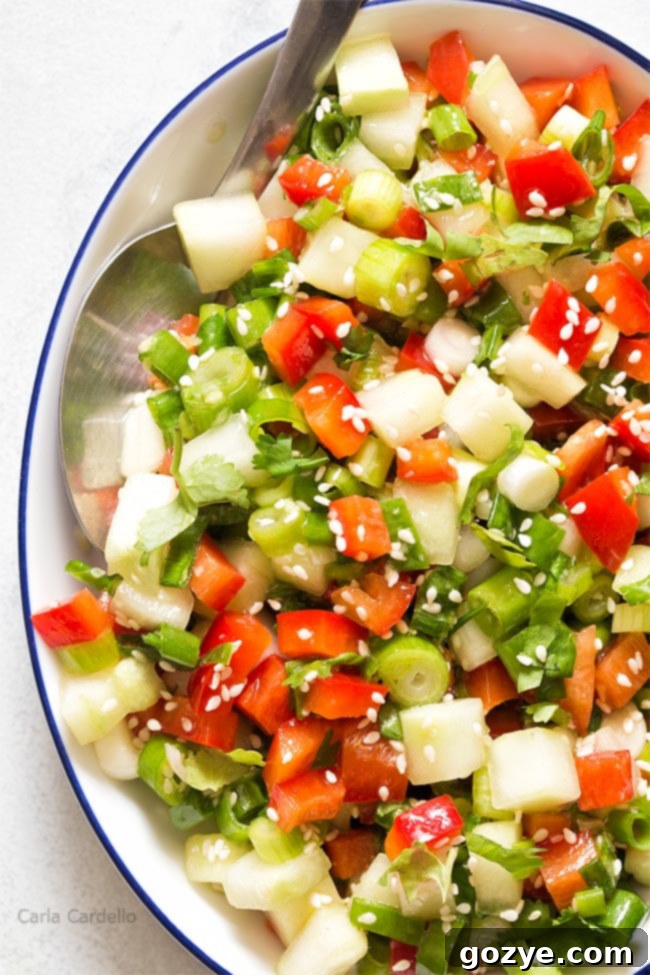 Close up of white bowl filled with green onion salad, highlighting the fresh texture of the vegetables