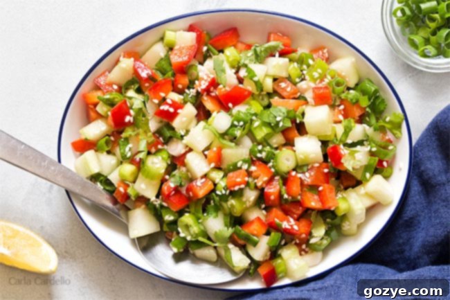 White bowl filled with green onion salad, presented on a wooden surface with a fork