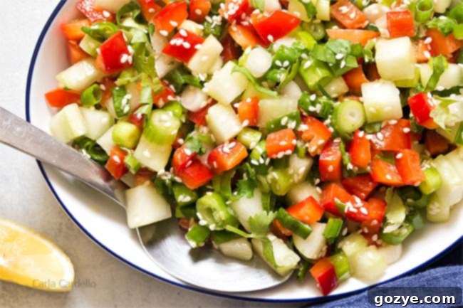 Close up of white bowl filled with green onion salad, showing the vibrant colors and fresh ingredients