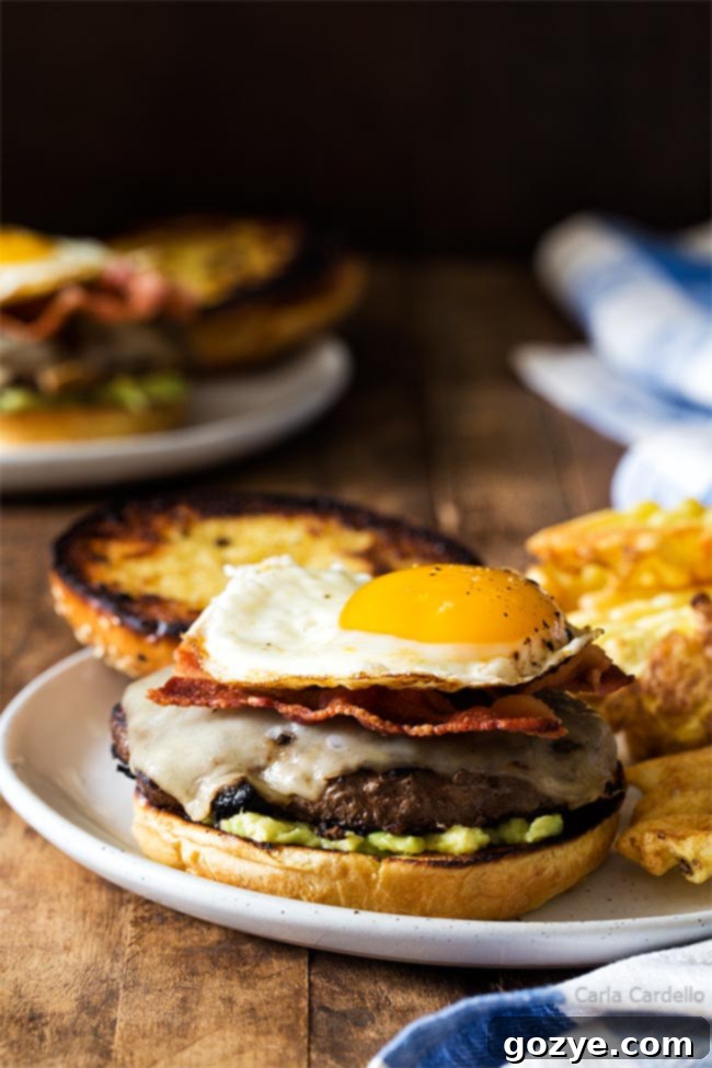 Golden Yolk Burger 3 Fried egg burger with top bun removed, showing the layers of cheese, bacon, and a perfectly cooked egg.