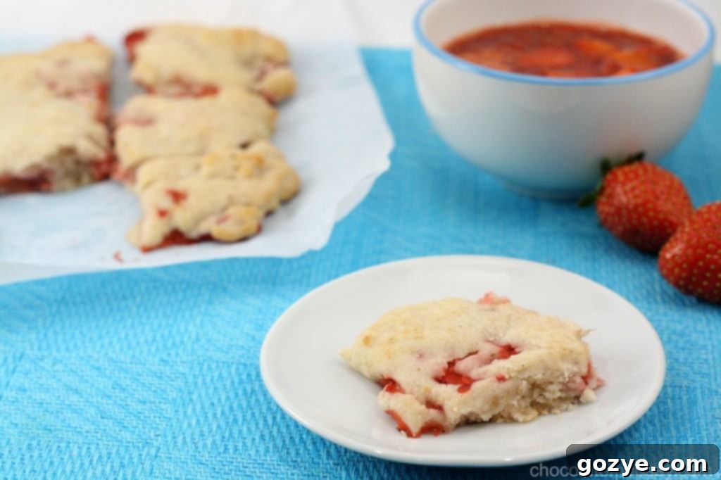 Close-up of a freshly baked Strawberry Cream Biscuit, showing the tender crumb and integrated strawberry pieces