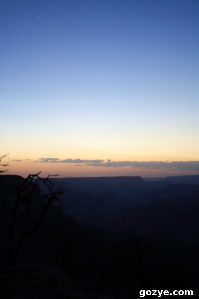 Grand Canyon at twilight, with a visible star or planet in the upper left corner.