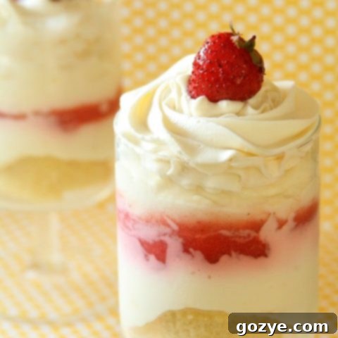 Strawberry Cheesecake Parfaits topped with whipped cream and a fresh berry