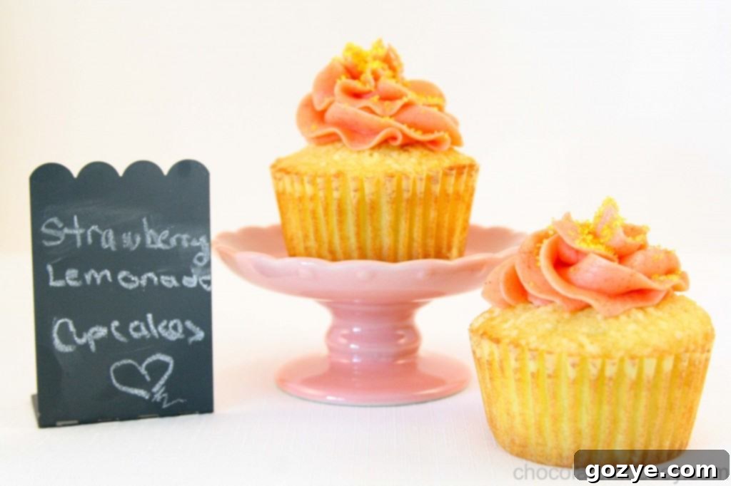 Delicious Strawberry Lemonade Cupcakes with strawberry curd buttercream frosting and fresh strawberries