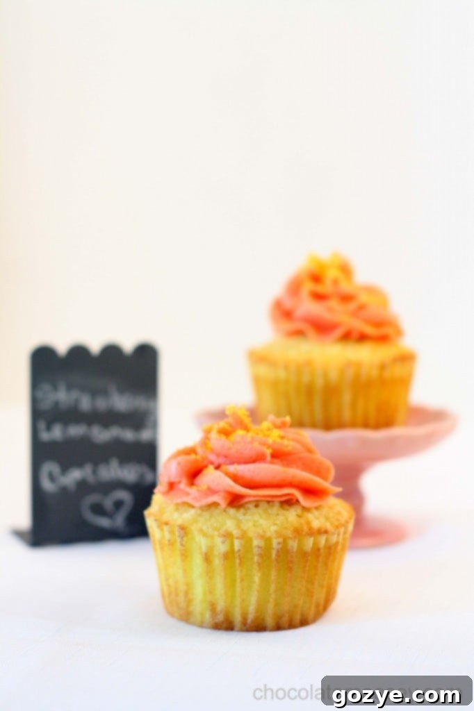 An assortment of Strawberry Lemonade Cupcakes on a wooden cutting board