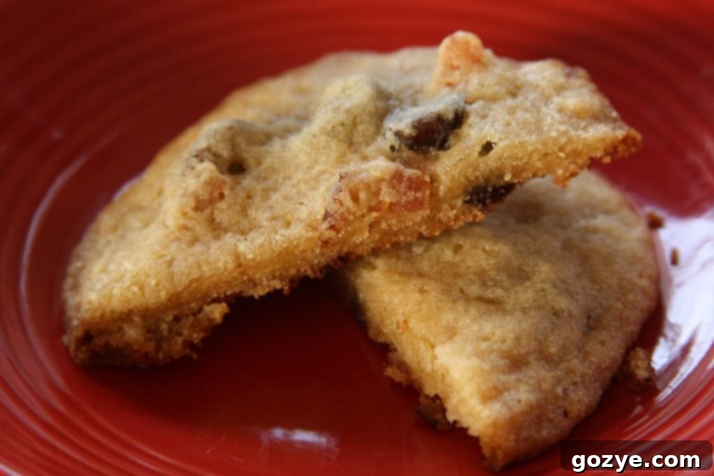 Two hands reaching for a fresh Bacon and Dried Cherry Chocolate Chip Cookie