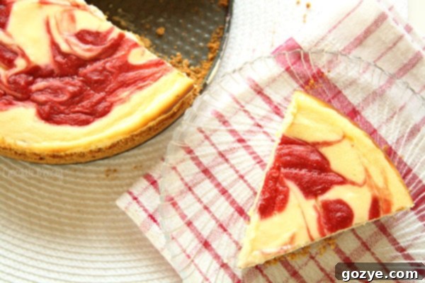 A serving of strawberry swirl cheesecake on a plate, ready to be enjoyed.