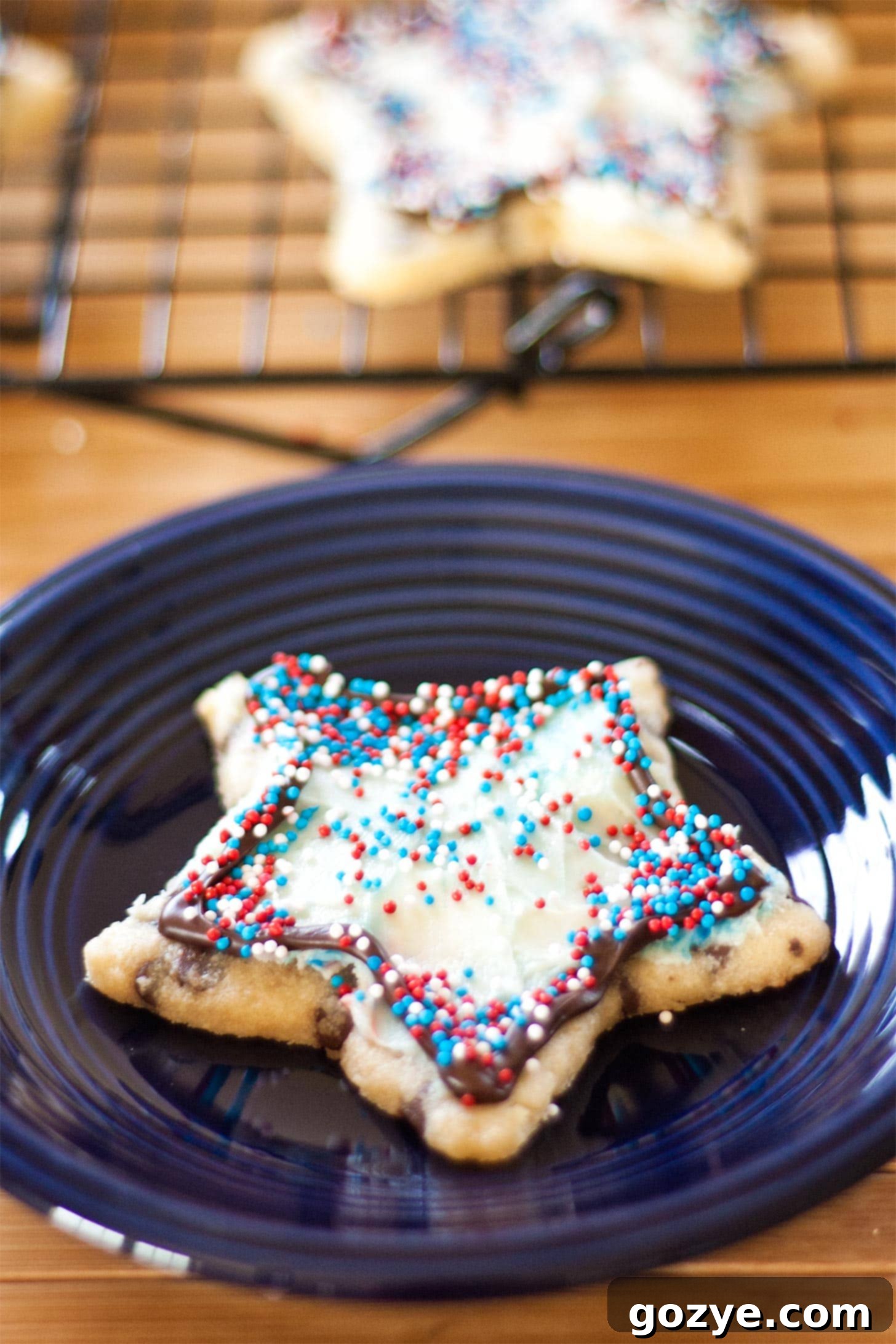 Star chocolate chip cut out cookie with red, white, and blue sprinkles on a blue plate