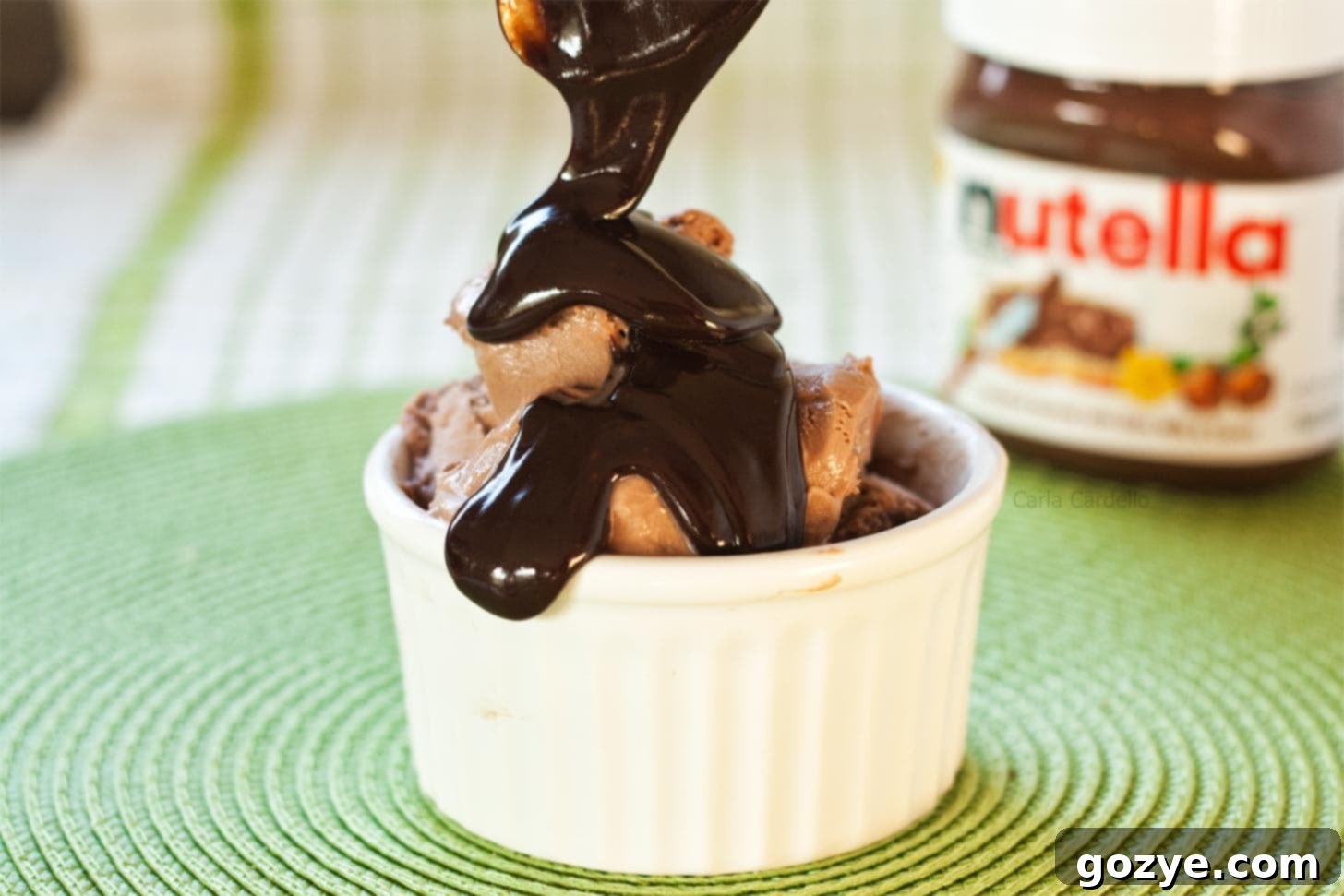 Nutella sauce being generously poured on top of a scoop of Nutella ice cream