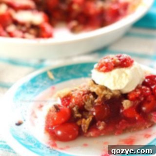 Cherry Crumble Pie with streusel topping and fresh cherries on the side, ready to be served.