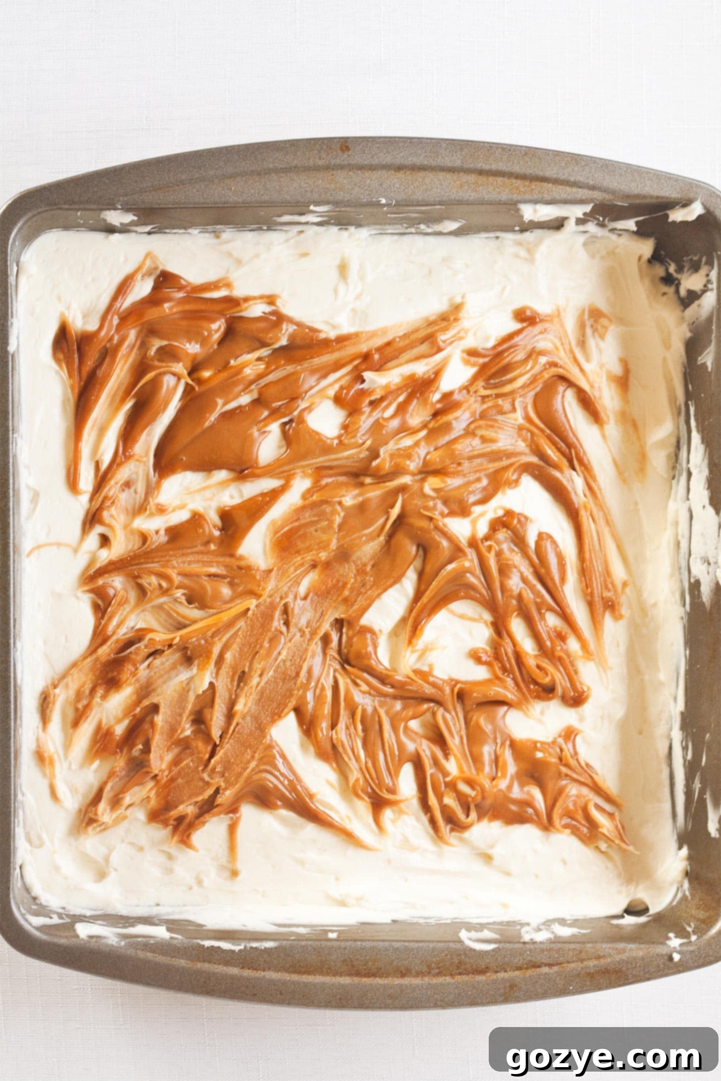 Biscoff No Bake Cheesecake in an 8x8 pan, with a perfectly smooth top, ready to be sliced