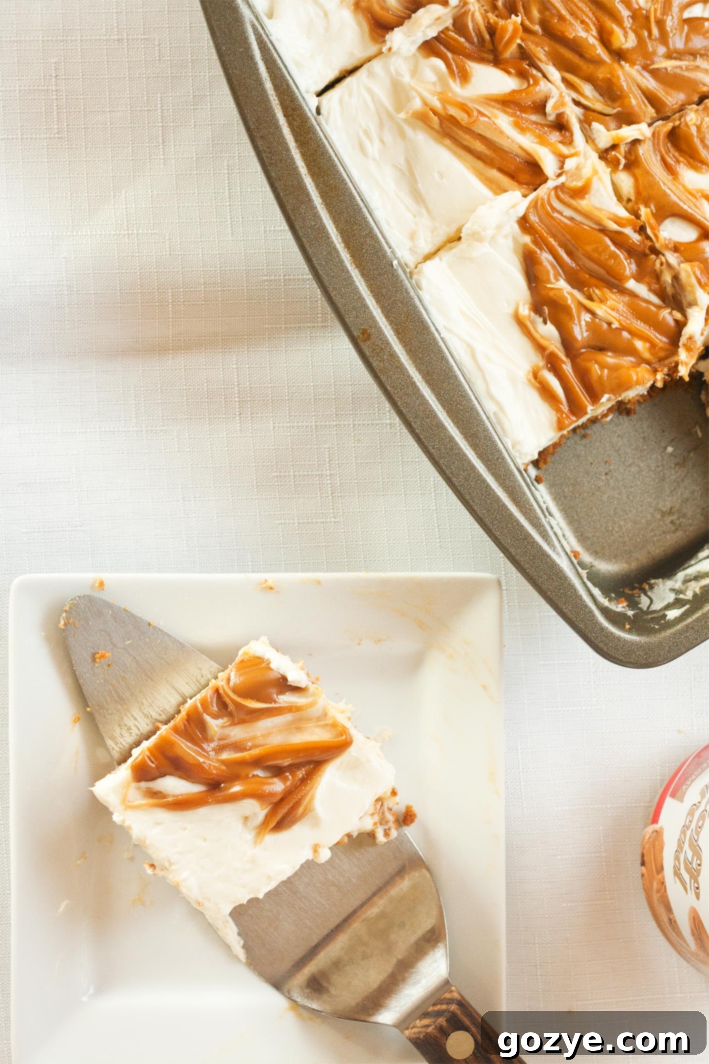 No bake Biscoff cheesecake bars served from an 8x8 pan, showcasing multiple perfectly sliced portions