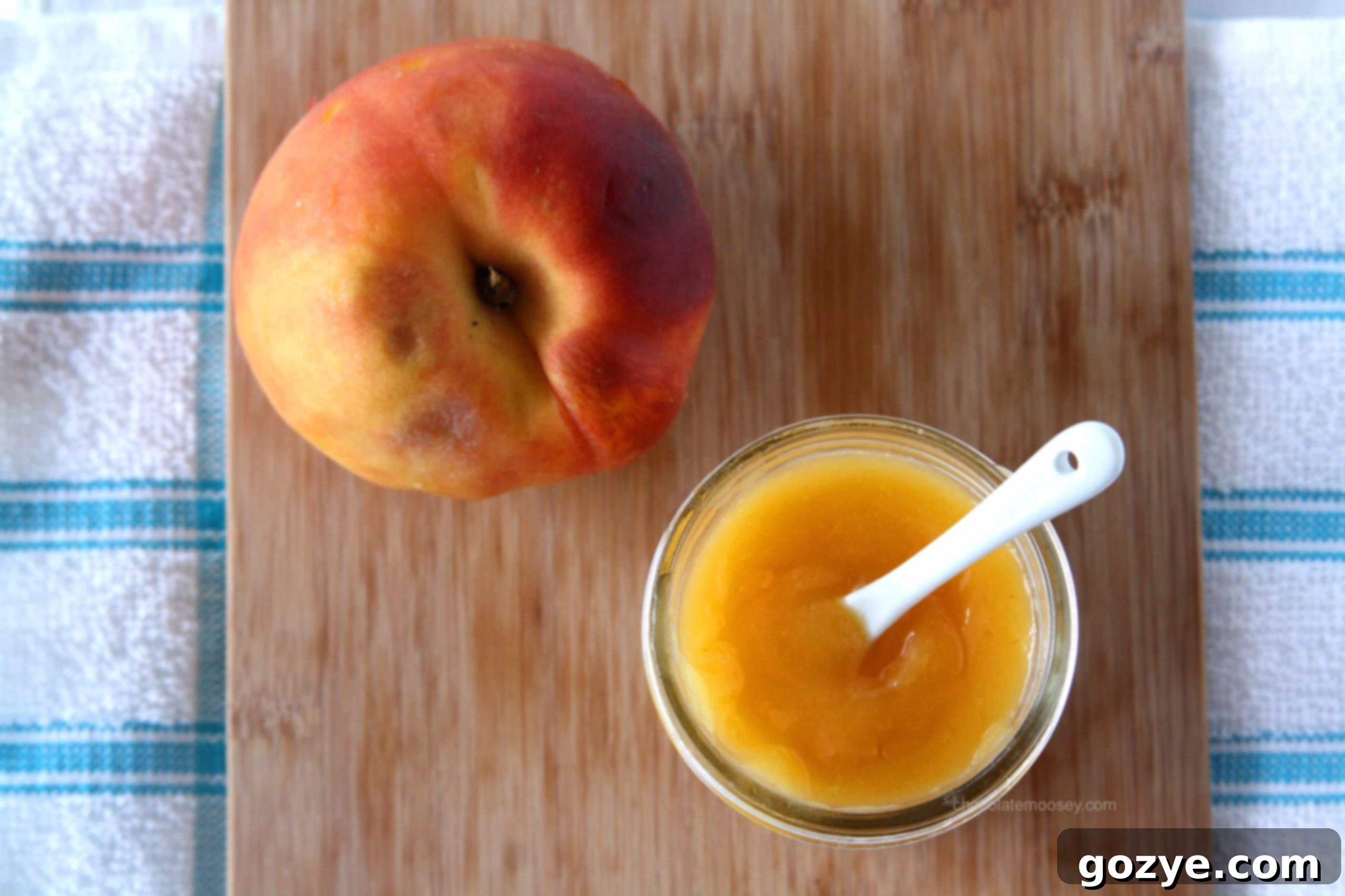 Peach Curd in a jar placed next to a fresh peach, highlighting natural ingredients